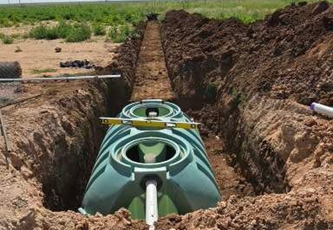 Septic tank being installed in a trench