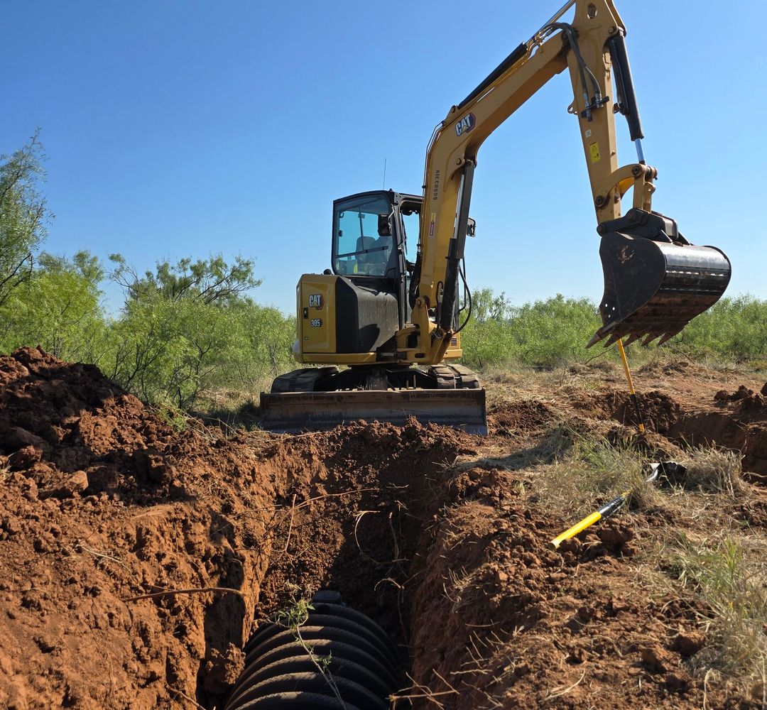 Excavator grading and clearing red-dirt raw land